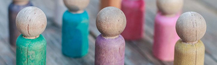 Bunte Holzspielfiguren in einer Gruppe